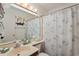 Clean bathroom featuring a vanity, mirror, and shower with a patterned curtain for privacy at 120 Dogwood Dr. N # 209, Murrells Inlet, SC 29576