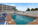Inviting swimming pool with lounge chairs, white fence and tropical plants, perfect for relaxing by the water at 120 Dogwood Dr. N # 209, Murrells Inlet, SC 29576