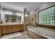 Elegant bathroom featuring double vanities, a glass shower, and a luxurious soaking tub for ultimate relaxation at 1204 Pine Valley Rd., North Myrtle Beach, SC 29582