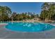 Beautiful large community pool surrounded by lounge chairs, mature trees, and a clear blue sky at 1204 Pine Valley Rd., North Myrtle Beach, SC 29582