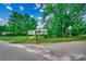 Exterior shot of home surrounded by lush green trees, manicured lawn, and a convenient carport at 1261 Parkhill Dr., Conway, SC 29526