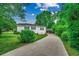 Charming home with a long driveway and carport, surrounded by lush greenery and beautiful landscaping at 1261 Parkhill Dr., Conway, SC 29526