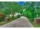 View of house with a long driveway, tree coverage and brick accent columns at 1261 Parkhill Dr., Conway, SC 29526