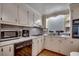 This kitchen features white cabinets, a range, microwave, and double basin sink under a window at 1261 Parkhill Dr., Conway, SC 29526