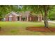 Charming brick home with a well-manicured lawn and red shutters, framed by mature trees at 127 Pinfeather Trail, Myrtle Beach, SC 29588