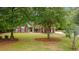 Beautiful brick home with vibrant green lawn and landscaped front yard, enhanced by mature trees at 127 Pinfeather Trail, Myrtle Beach, SC 29588