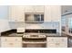 Close up of kitchen area with white cabinets, granite countertops, and stainless steel appliances at 127 Pinfeather Trail, Myrtle Beach, SC 29588