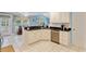 Well-lit kitchen showcasing white cabinetry, stainless steel dishwasher, and granite countertops, and tile floors at 127 Pinfeather Trail, Myrtle Beach, SC 29588