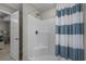 Bright bathroom featuring a shower with a striped curtain and an open doorway at 1307 Collins Park St., Conway, SC 29526