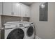 Modern laundry room with white cabinets and a Samsung washer and dryer set at 1307 Collins Park St., Conway, SC 29526