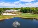Expansive aerial view of the clubhouse, golf course, and a picturesque pond with a fountain at 141-4 Weehawka Way # 4, Pawleys Island, SC 29585
