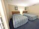 Bedroom with two beds and floral wall art, offering a peaceful retreat with comfortable furnishings at 141-4 Weehawka Way # 4, Pawleys Island, SC 29585