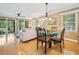 Cozy dining area with glass table, seating for four, bright windows, and access to the living room at 141-4 Weehawka Way # 4, Pawleys Island, SC 29585