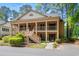 Charming two-story condo with a covered front porch and wooden stairs, surrounded by lush landscaping at 141-4 Weehawka Way # 4, Pawleys Island, SC 29585