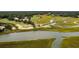 An aerial view of a golf course featuring marshy areas, a bridge, and nearby houses at 141-4 Weehawka Way # 4, Pawleys Island, SC 29585