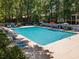 Aerial view of a community pool with lounge chairs and umbrellas surrounded by trees at 141-4 Weehawka Way # 4, Pawleys Island, SC 29585