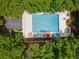 An aerial view of a community pool with lounge chairs and umbrellas, surrounded by green trees at 141-4 Weehawka Way # 4, Pawleys Island, SC 29585