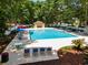 Aerial view of the community pool featuring lounge chairs and umbrellas surrounded by trees at 141-4 Weehawka Way # 4, Pawleys Island, SC 29585