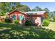 The side of this brick house with a grass yard is accented by green shutters at 152 Gateway Dr., Little River, SC 29566