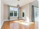 Bright dining room features hardwood floors, a large window with backyard views, and modern lighting fixtures at 1549 Kensington Ln., Myrtle Beach, SC 29577