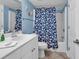 Bathroom featuring vanity, toilet, and shower-tub combo with blue seashell-themed shower curtain at 1620 N Waccamaw Dr. # 103, Garden City Beach, SC 29576