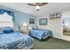 Serene bedroom with two beds, blue accents, and a ceiling fan offering a relaxing retreat at 1620 N Waccamaw Dr. # 103, Garden City Beach, SC 29576