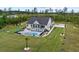 Aerial view showcasing the home, pool, spacious backyard, and surrounding landscaping at 1763 Hemingway Rd., Loris, SC 29569