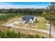 Aerial view of home showcasing well-manicured landscaping, gravel driveway, and a forest backdrop at 1763 Hemingway Rd., Loris, SC 29569