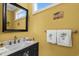 A well-lit half bath features a framed mirror and white towels with palm tree embroidery at 1763 Hemingway Rd., Loris, SC 29569
