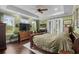 Light-filled main bedroom with hardwood floors, a ceiling fan, and access to a private patio at 1763 Hemingway Rd., Loris, SC 29569