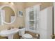 Charming bathroom features a pedestal sink, storage cabinet, and window with natural light at 190 Barony Pl., Pawleys Island, SC 29585