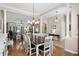 Open-concept dining area with elegant chandelier lighting and hardwood floors, flowing into the living room at 190 Barony Pl., Pawleys Island, SC 29585