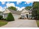 Attractive single-story home with beige siding, two car garage and beautifully manicured front lawn at 190 Barony Pl., Pawleys Island, SC 29585