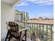 Balcony view with bar chairs overlooking a swimming pool and tall building at 201 Ocean Blvd. S # 1505, North Myrtle Beach, SC 29582