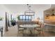 Bright dining area with a glass-top table, ornate chandelier, and ocean views visible in the background at 201 Ocean Blvd. S # 1505, North Myrtle Beach, SC 29582