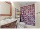 Bathroom with dark vanity and wooden framed mirror and coordinated patterned shower curtain at 2019 Ye Olde Kings Hwy., North Myrtle Beach, SC 29582