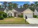 Inviting single-story home with a manicured lawn, brick details, and an attached two-car garage at 202 Glenwood Dr., Conway, SC 29526