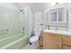 Cozy bathroom featuring a shower, toilet, vanity and sink with wood paneled cabinet at 206 Dogwood Dr., Myrtle Beach, SC 29575