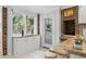 Cozy eat-in kitchen with white cabinets, brick details, a pass-through bar and a large window at 206 Dogwood Dr., Myrtle Beach, SC 29575