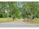 The property's entrance features a custom gate surrounded by lush trees and landscaping, creating a welcoming approach at 2776 Holly Rd., Marion, SC 29571