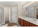 Bathroom featuring a dual sink vanity with a large mirror and a separate door to the toilet and shower at 3 Birdsong Ct., Murrells Inlet, SC 29576