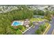 An aerial view of the community pool, tennis courts, and clubhouse in a lush, green setting at 3 Birdsong Ct., Murrells Inlet, SC 29576