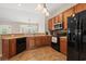 Open kitchen with wood cabinets, black appliances, and seamless flow into the living space at 3 Birdsong Ct., Murrells Inlet, SC 29576