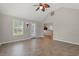 Living room with a ceiling fan, access to the kitchen, and a view of the backyard through large windows at 3 Birdsong Ct., Murrells Inlet, SC 29576