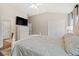 Bright main bedroom with wood floors, an ensuite bathroom, and a TV mounted above a dresser at 3 Birdsong Ct., Murrells Inlet, SC 29576