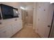 Bathroom featuring a dual sink vanity, walk-in shower with glass door, and neutral-toned tile flooring at 306 Southgate Ct., Pawleys Island, SC 29585
