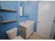 Bathroom with blue walls features floating wood shelves, custom vanity, and decorative mirror at 306 Southgate Ct., Pawleys Island, SC 29585