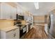 Kitchen with stainless steel appliances, stone countertops, white cabinets, and wood flooring at 3565 Steamer Trace Rd., Conway, SC 29527