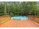 An above-ground pool surrounded by a wooden deck in a lush, green, wooded backyard at 3565 Steamer Trace Rd., Conway, SC 29527