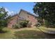 Large backyard with a brick home exterior, lush trees, a patio area, and hammock for relaxing at 3605 Kingsley Dr., Myrtle Beach, SC 29588